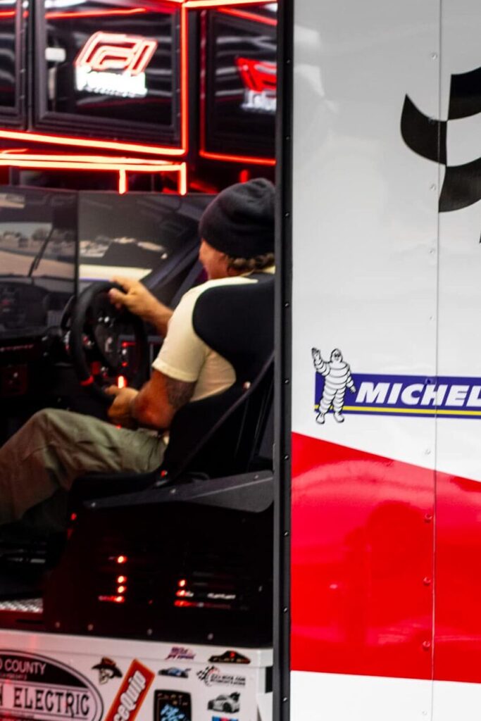 Person driving a racing simulator with screens